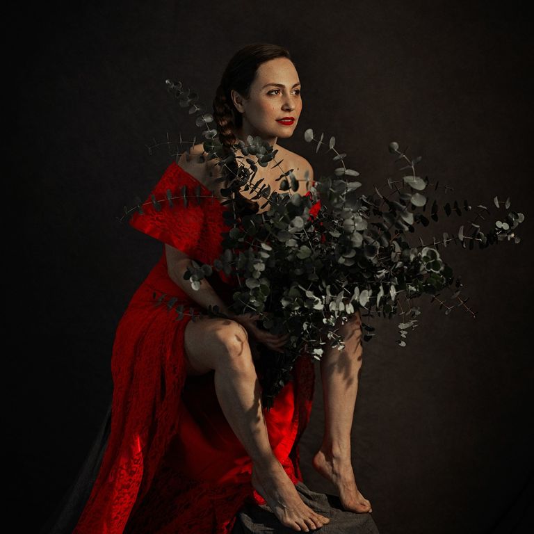 Mujer con vestido rojo y ramo de eucalipto